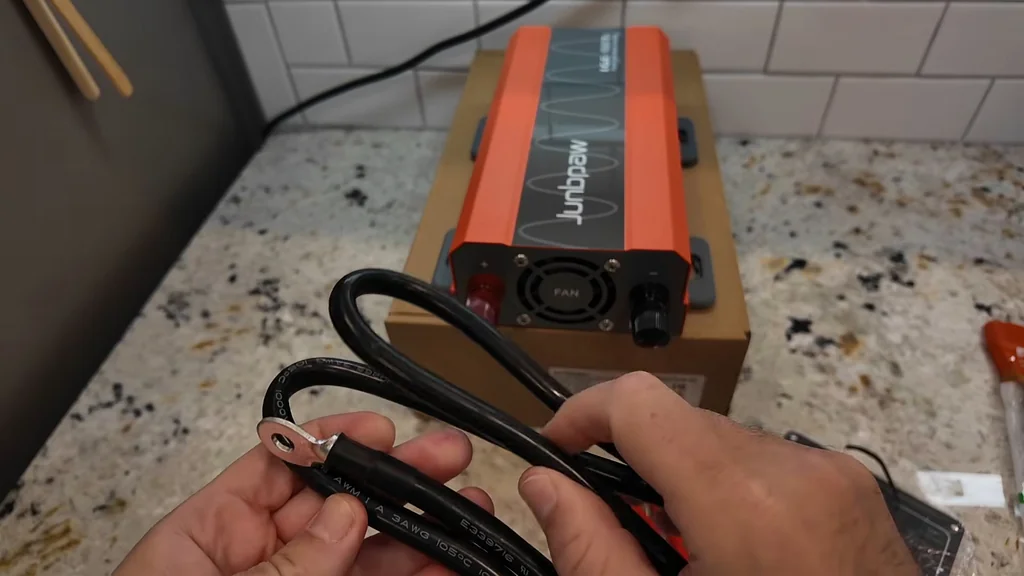 Hands securing battery cables to terminals
