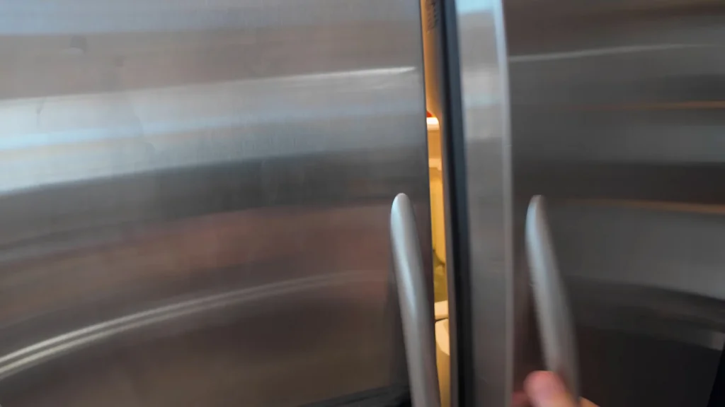 Hand opening the refrigerator to test power stability