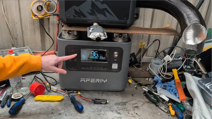 USB inline tester displaying 5V rail voltage and current load on front panel display