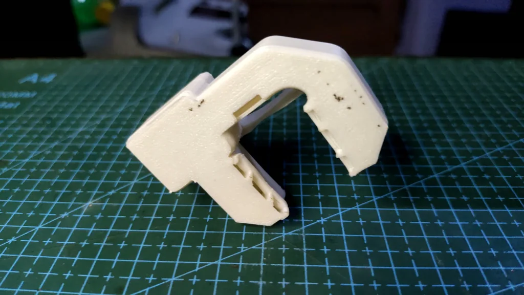 White 3D printed bracket being installed on the hotend