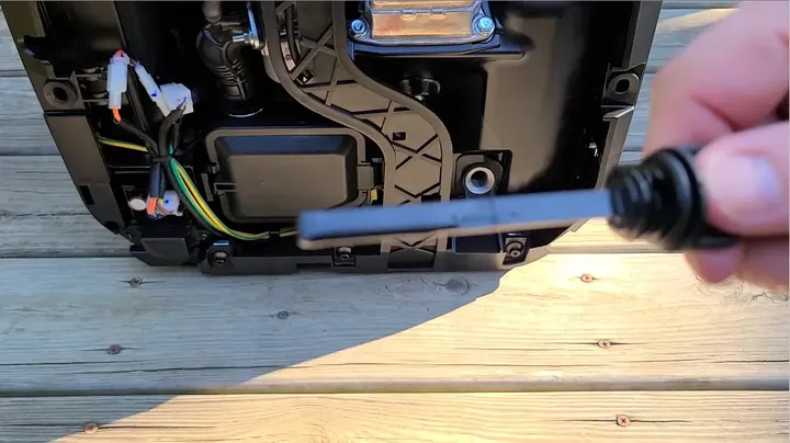 Pouring engine oil into generator fill neck using flexible plastic funnel