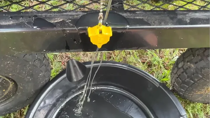 Break-in oil draining from flexible hose into an oil pan