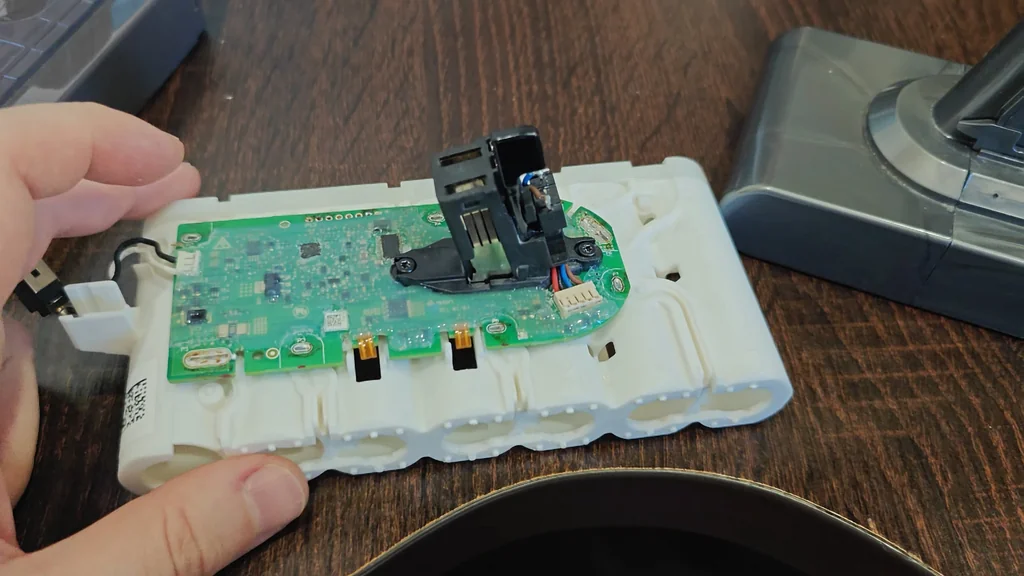 Hand holding Dyson battery PCB