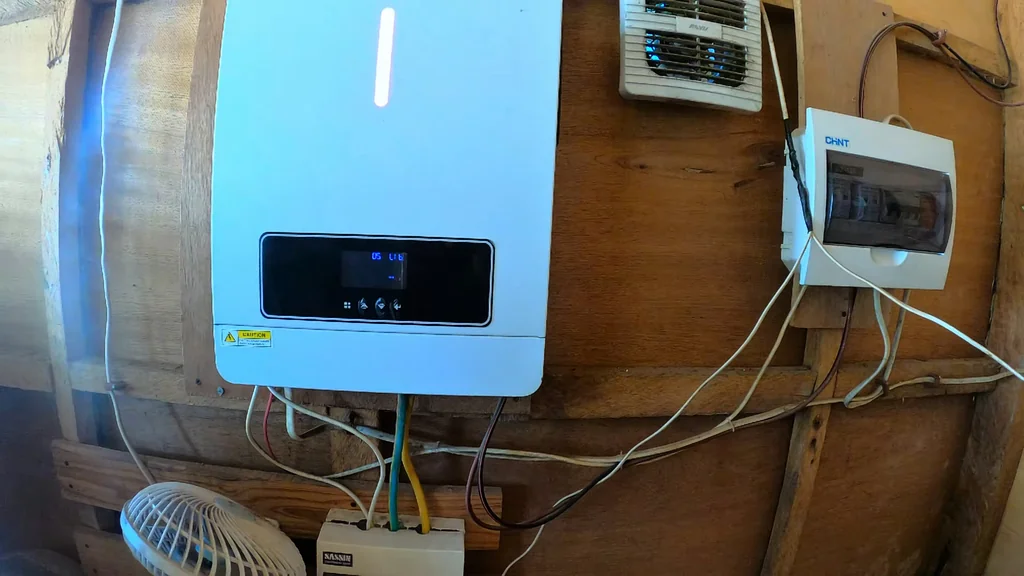 Inverter mounted on a wooden wall showing output.