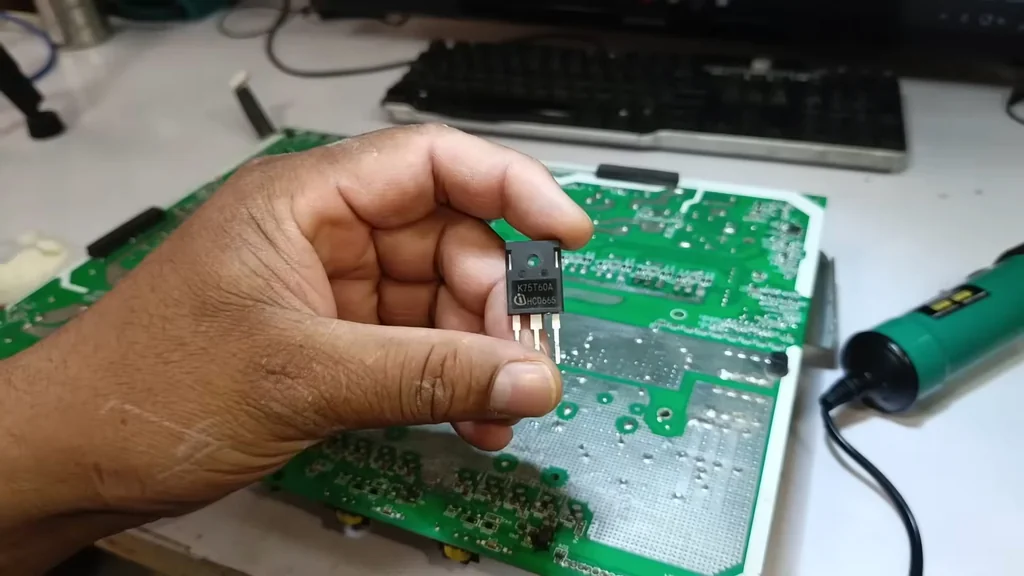 Hand holding K20T60A power transistor
