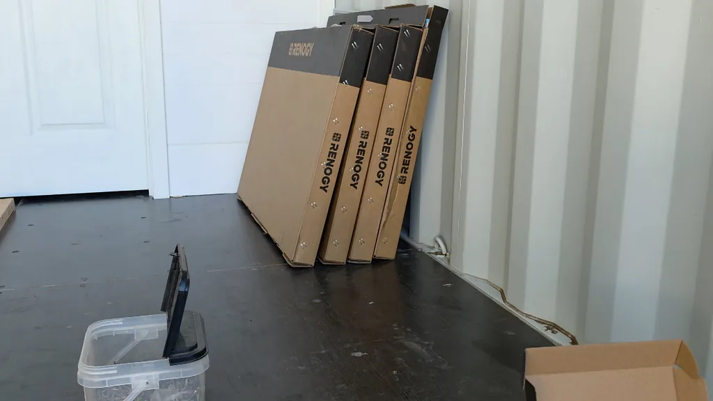 Four black T-post brackets arranged on a flat surface.