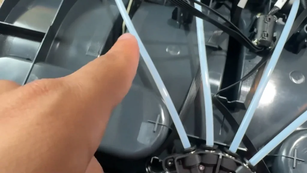 Hand pointing at 3D printer filament tubes