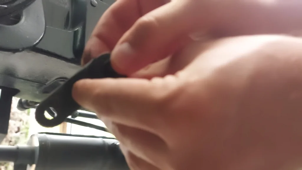 Holding a small black linkage part