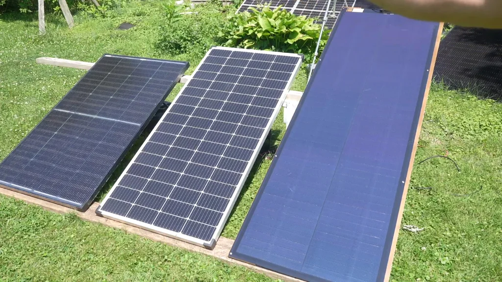Three solar panels laid out on grass for testing