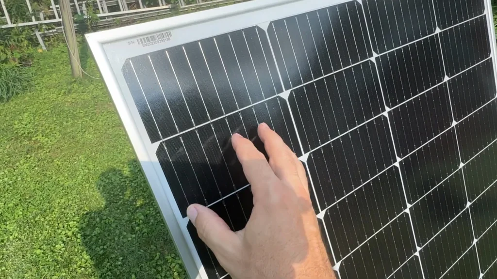 Hand touching the surface of a solar cell