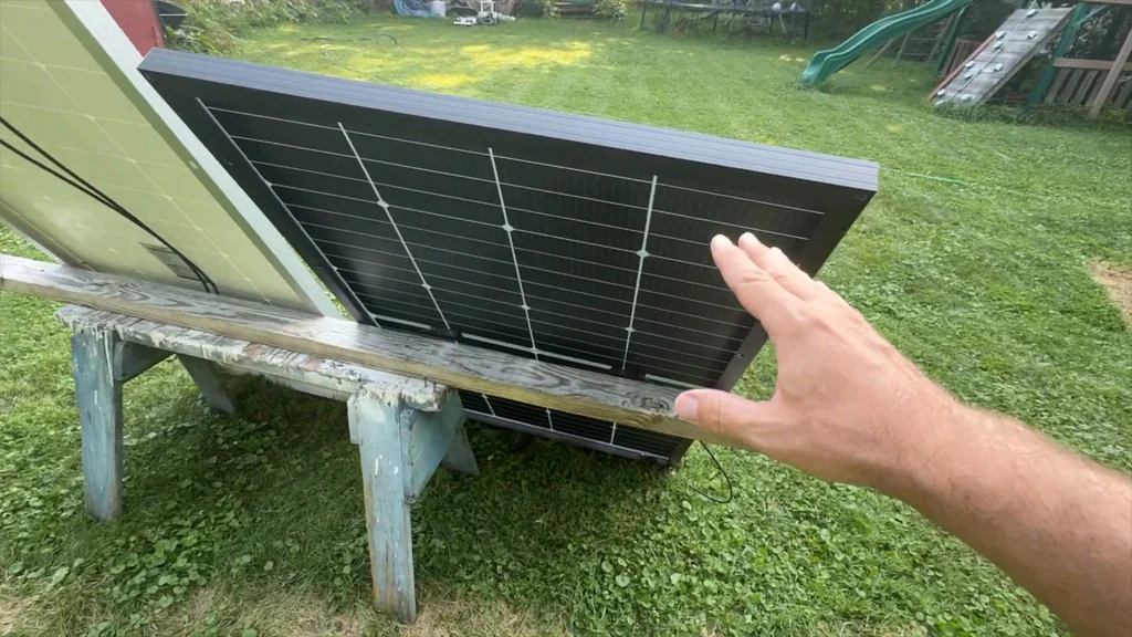 Hand pointing at a solar panel on a workbench