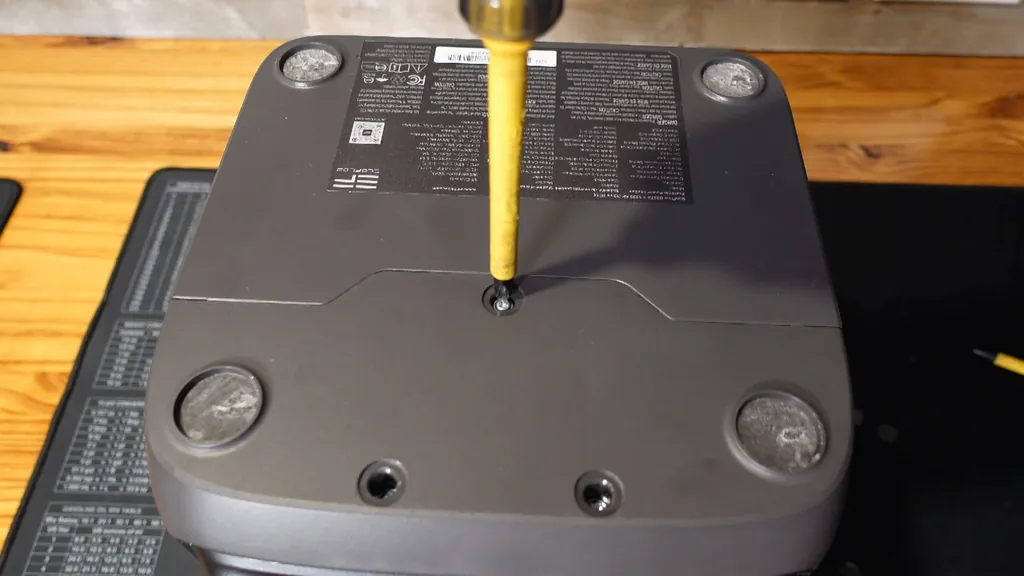 Screwdriver removing Phillips screws from the power station casing