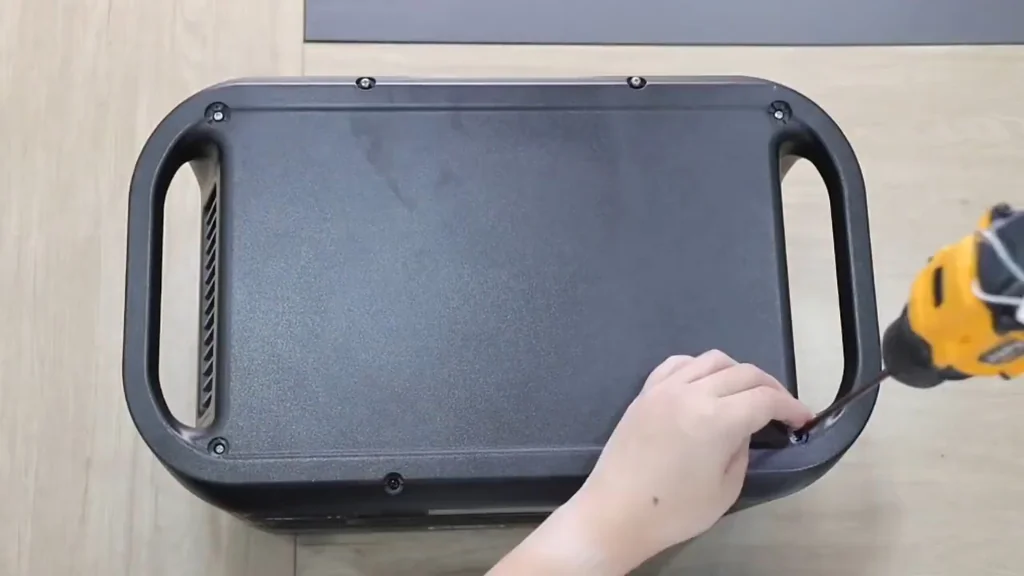 Unscrewing the power station cover with a drill