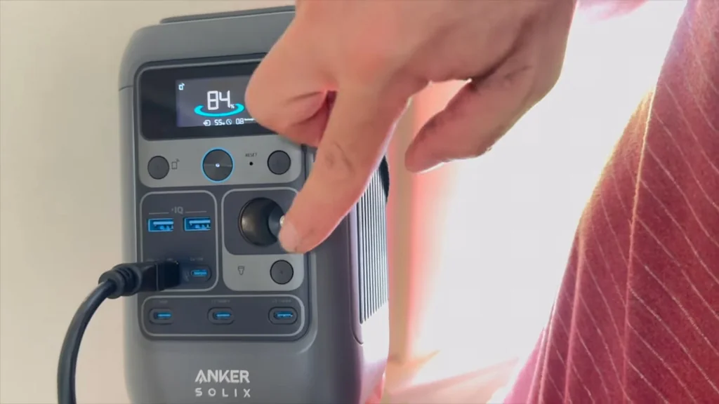Finger pressing a mode button on the power station