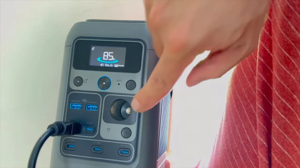 Finger pressing the DC car socket button