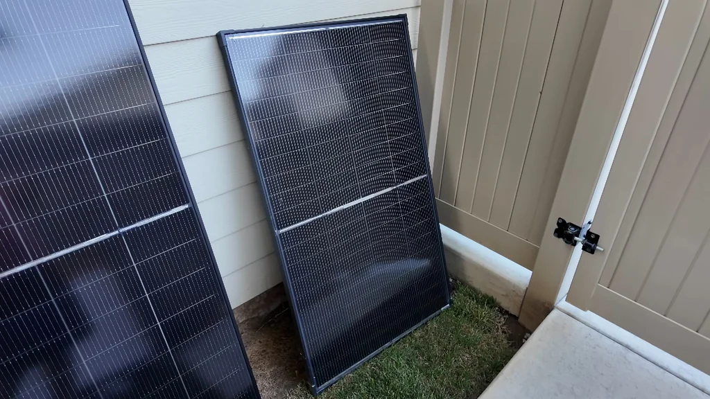 Two solar panels leaning against a wall