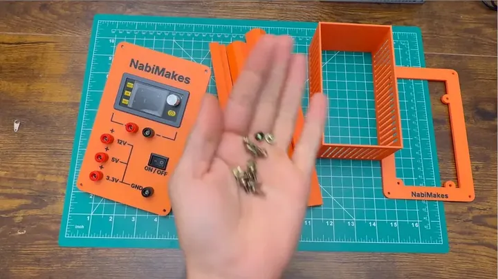Hands aligning printed structural frame sections and salvaged machine screws against the metal ATX chassis