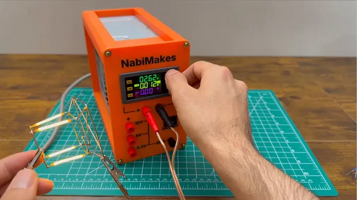 Finished bench power supply actively powering an intricate, brightly glowing LED cube on the workshop table