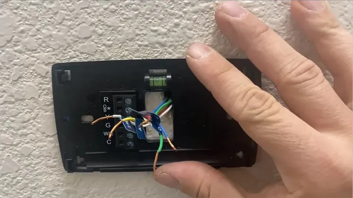 Close-up of integrated green bubble level centered in the smart thermostat mounting plate