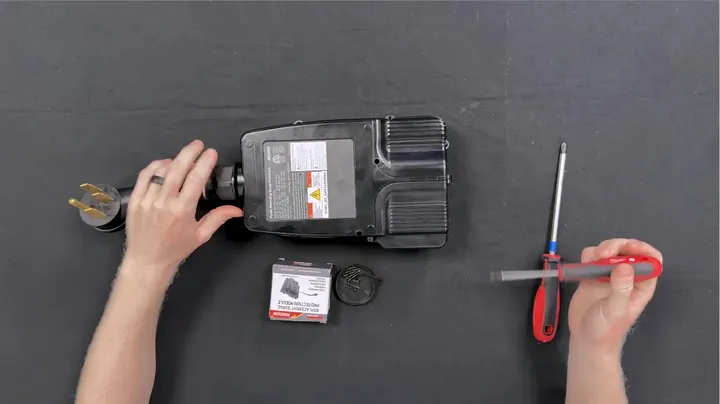 Phillips screwdriver removing outer screws from back of surge protector casing